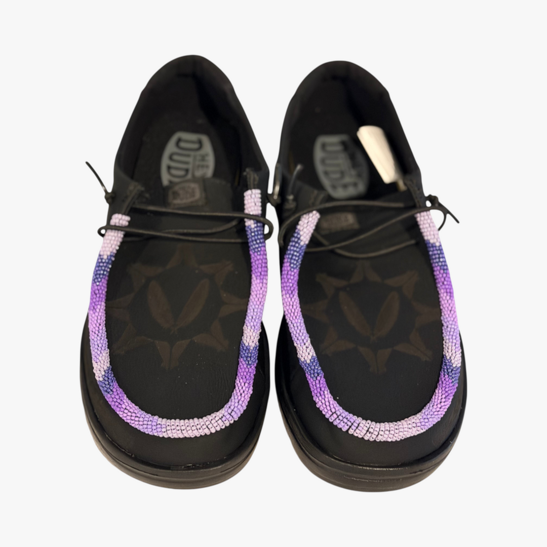 All Nations Designs &amp; More black Hey Dude leather slip-on shoes featuring unique purple and white hand-beaded trim.