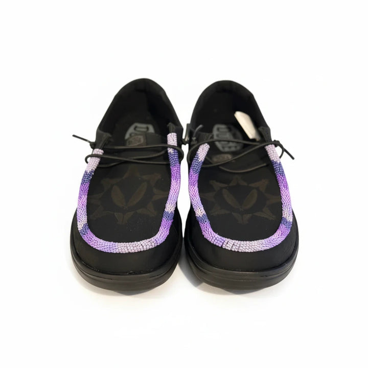 All Nations Designs &amp; More black leather Hey Dude slip-on shoes featuring custom purple and white hand-beaded trim