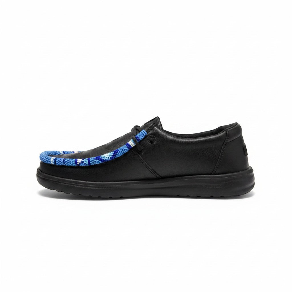 All Nations Designs &amp; More black Hey Dude slip-on shoes featuring unique blue and white hand-beaded trim detail.