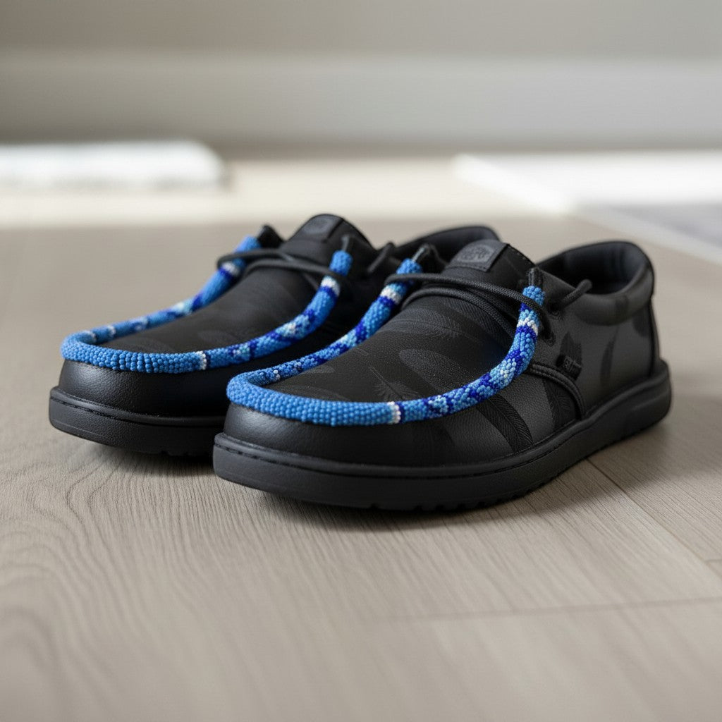All Nations Designs &amp; More black Hey Dude slip-on shoes featuring unique blue and white hand-beaded trim details.