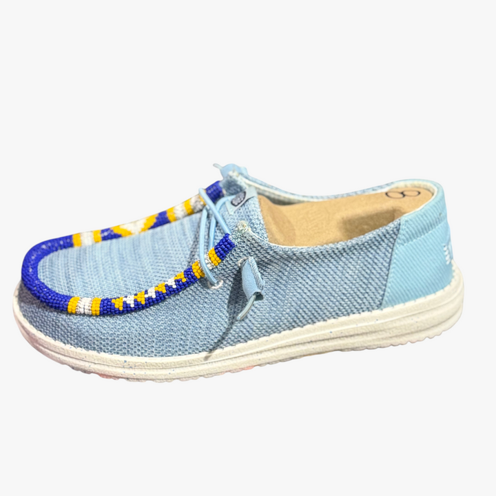 All Nations Designs &amp; More hand-beaded blue mesh slip-on shoes with yellow and white patterned beadwork trim.