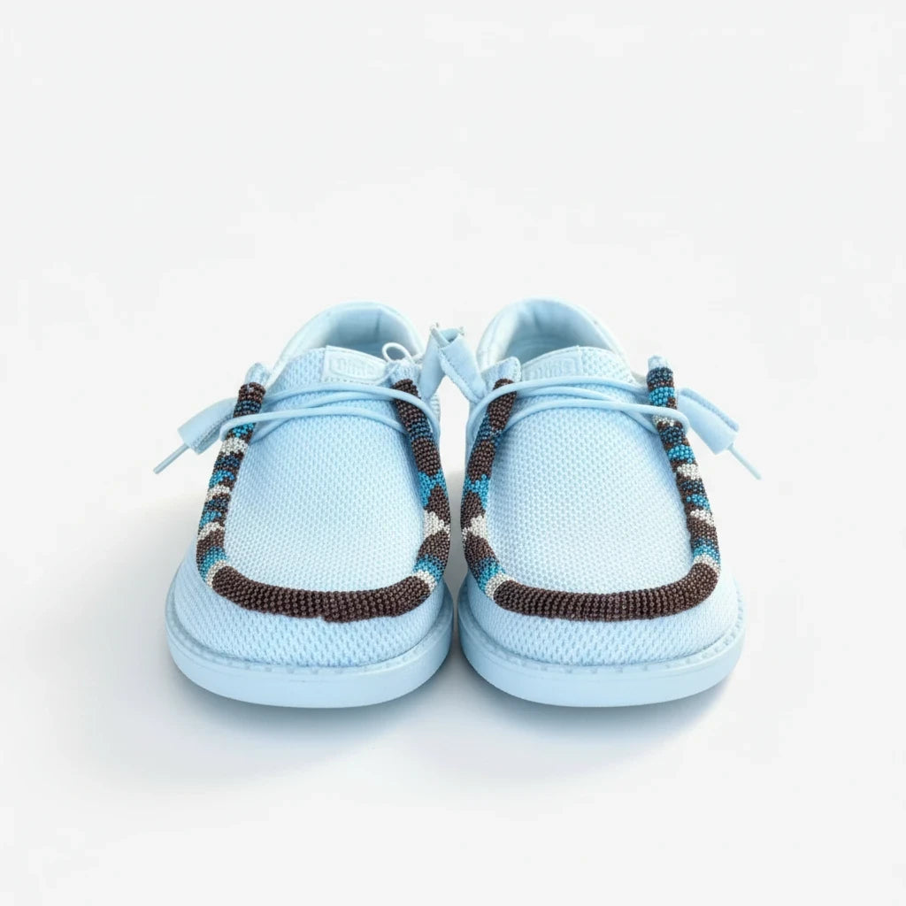 All Nations Designs &amp; More hand-beaded light blue mesh slip-on shoes with brown and blue patterned beadwork detail.