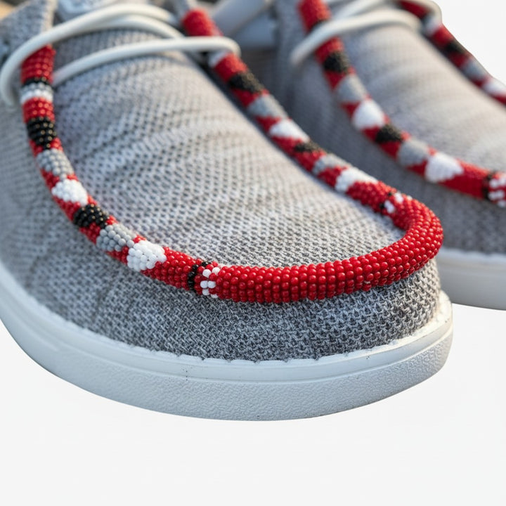 All Nations Designs &amp; More gray mesh Hey Dude slip-on shoes featuring custom red, white, and black hand-beaded trim.