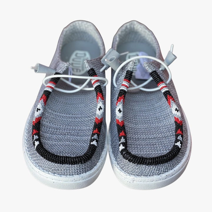 All Nations Designs &amp; More light gray Hey Dude slip-on shoes featuring custom red, black, and white hand-beaded trim.
