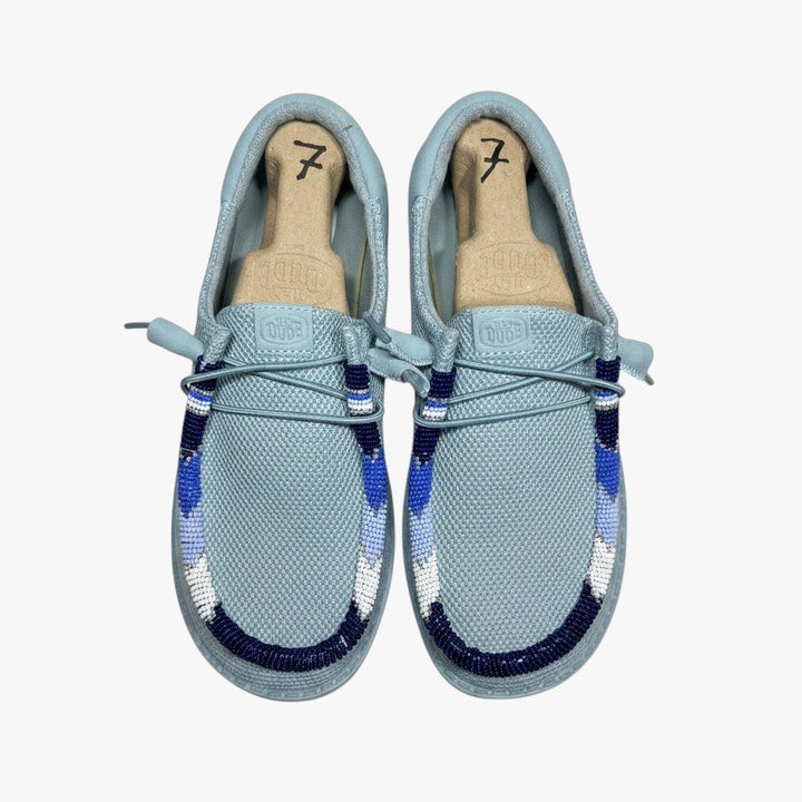 All Nations Designs &amp; More hand-beaded Hey Dude slip-on shoes in mesh tourmaline blue with custom blue beadwork.