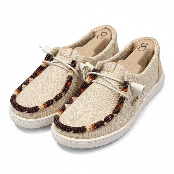 All Nations Designs &amp; More hand-beaded Hey Dude slip-on shoes in Irish cream mesh with brown and tan beadwork details.
