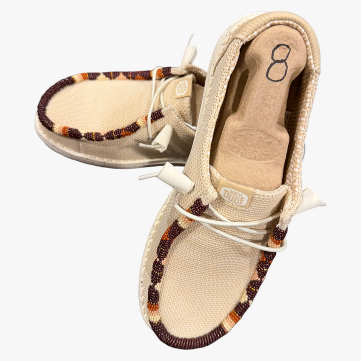All Nations Designs &amp; More hand-beaded Hey Dude slip-on shoes in Irish cream mesh with brown and orange beadwork.