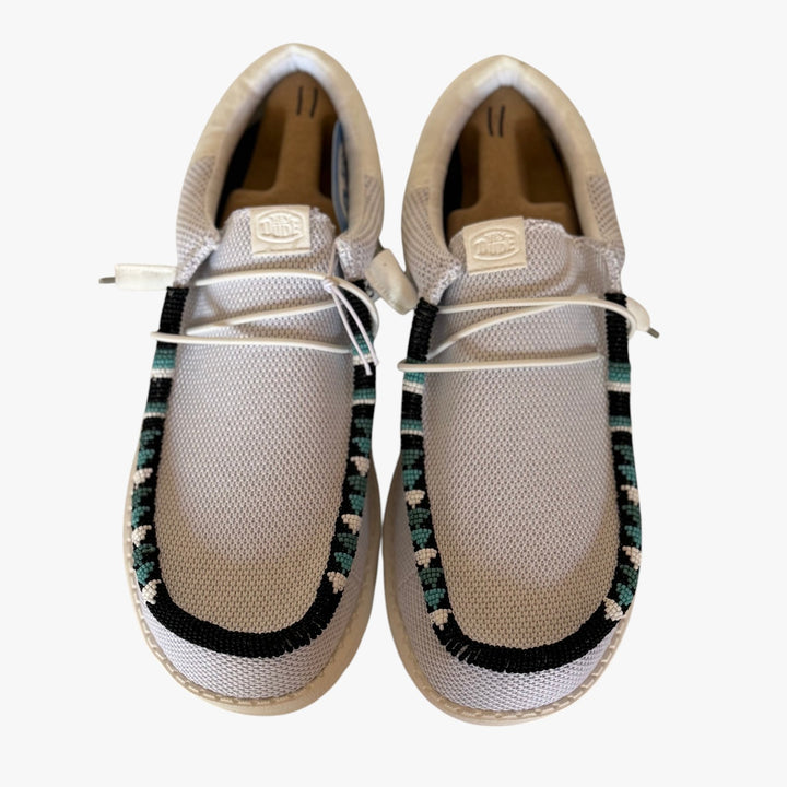All Nations Designs &amp; More light gray mesh Hey Dude slip-on shoes featuring custom black, white, and teal beadwork.