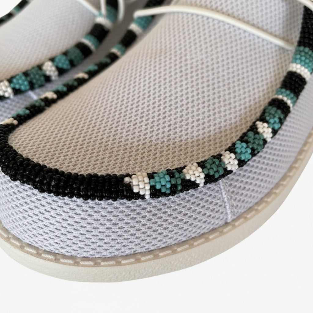 All Nations Designs &amp; More light gray mesh slip-on shoes featuring intricate black, white, and teal hand-beaded trim.