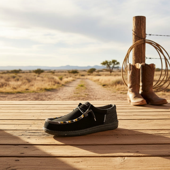 All Nations Designs &amp; More hand-beaded black and gray mesh slip-on shoes on a wooden deck with western decor