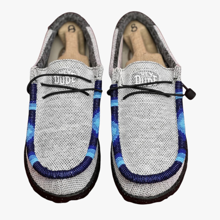 All Nations Designs &amp; More light gray mesh Hey Dude slip-on shoes featuring unique blue and navy hand-beaded detailing.