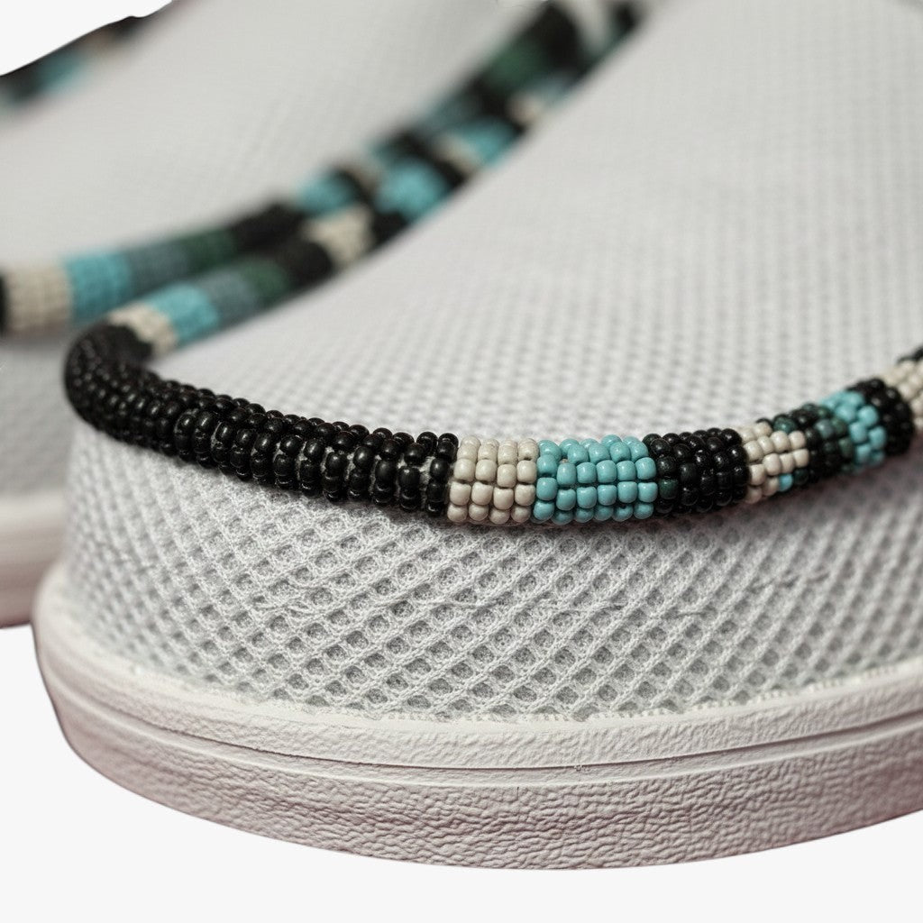 All Nations Designs &amp; More light gray mesh slip-on shoes featuring custom black, white, and turquoise hand-beaded trim.
