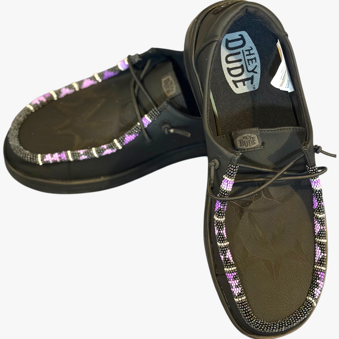 All Nations Designs &amp; More black Hey Dude leather slip-on shoes featuring custom purple and white hand-beaded trim.