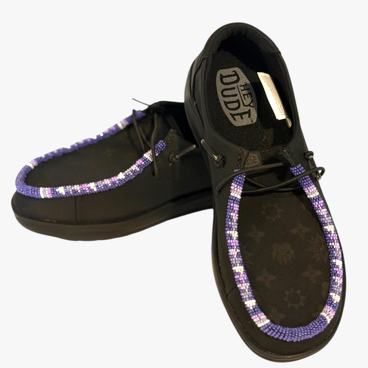 All Nations Designs &amp; More black Hey Dude leather slip-on shoes featuring custom purple and white hand-beaded trim.