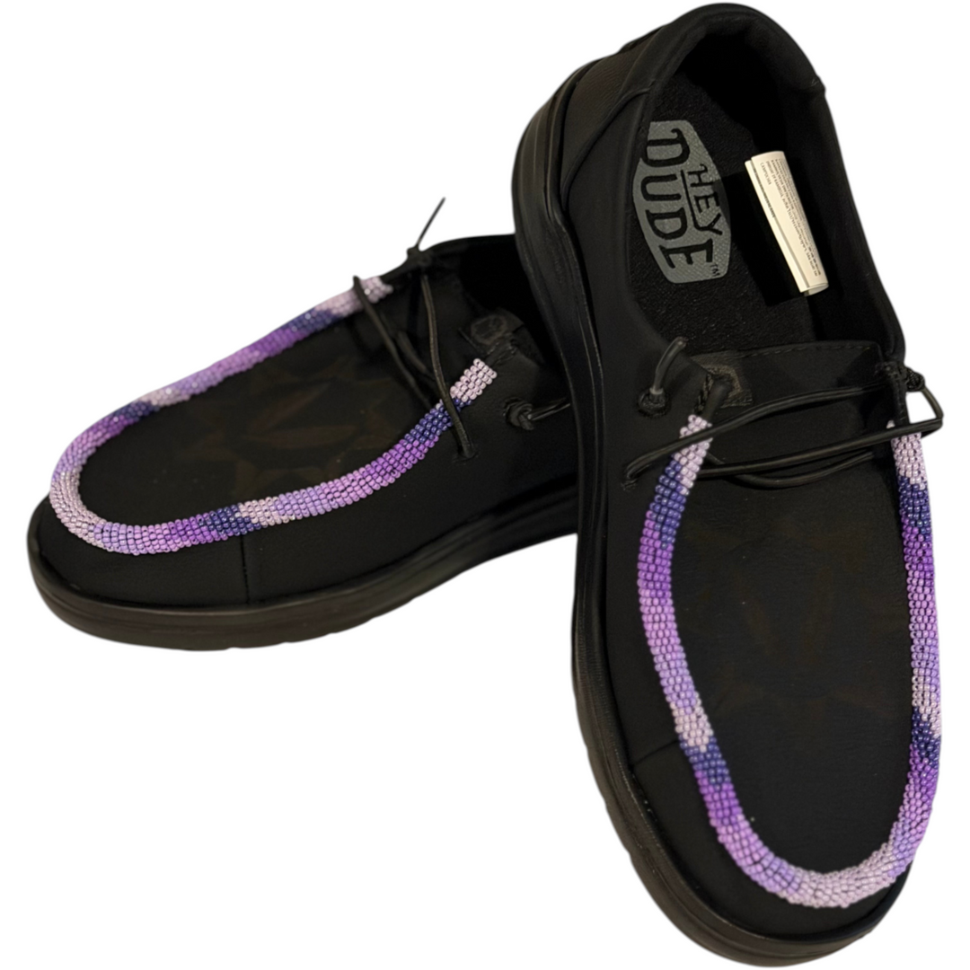 All Nations Designs &amp; More black Hey Dude slip-on shoes featuring unique purple and white hand-beaded trim.
