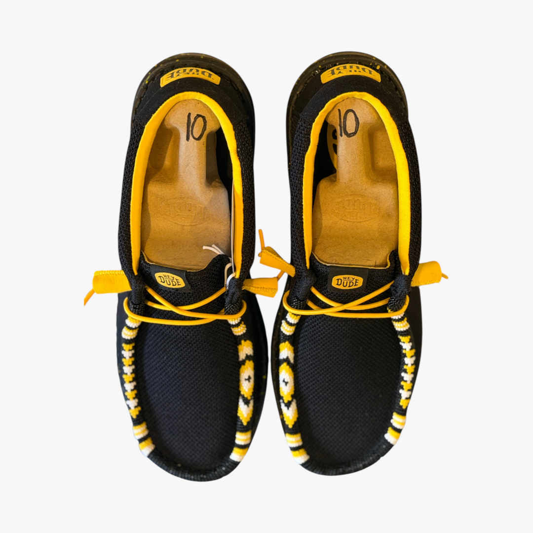 All Nations Designs &amp; More black Hey Dude slip-on shoes featuring custom yellow and white hand-beaded western patterns.