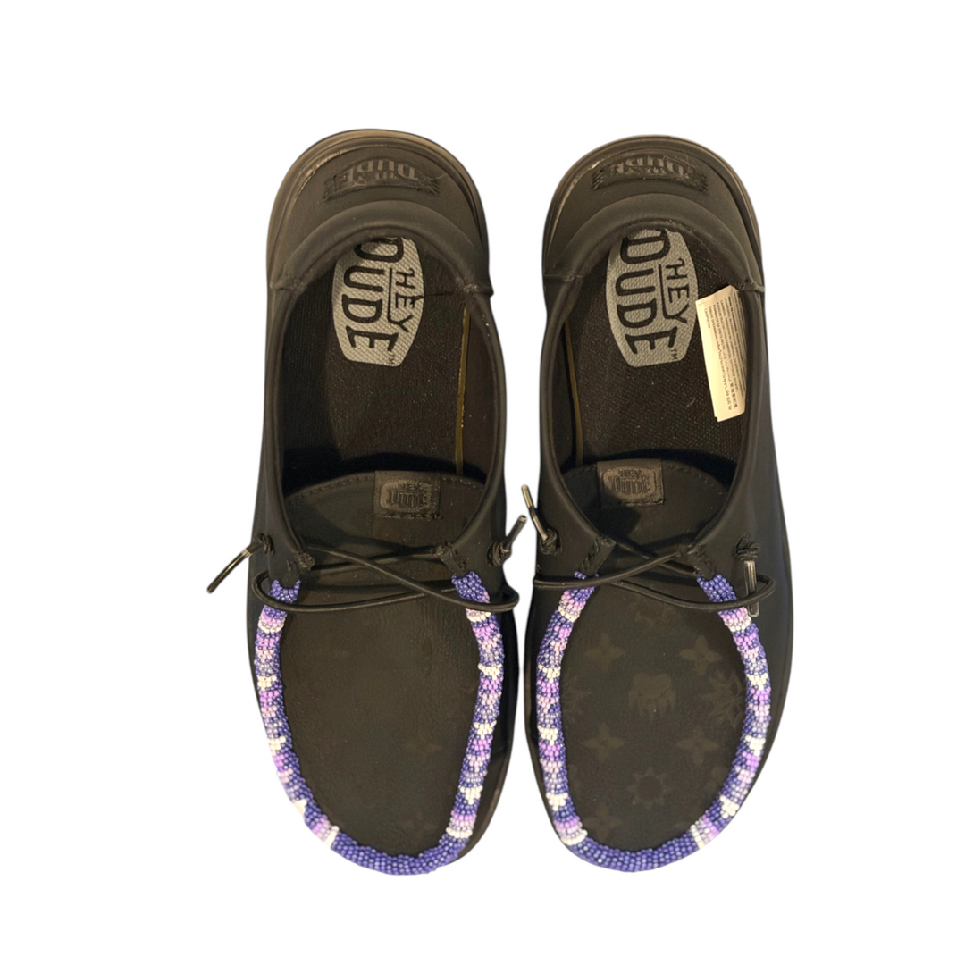 All Nations Designs &amp; More black Hey Dude leather slip-on shoes featuring unique purple and white hand-beaded trim.