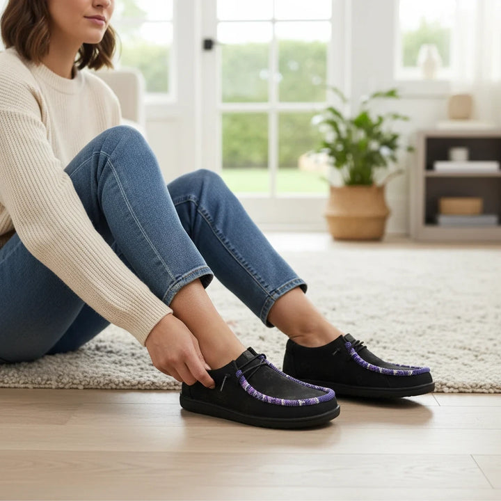 All Nations Designs &amp; More black leather Hey Dude slip-on shoes featuring custom purple and white hand-beaded trim.