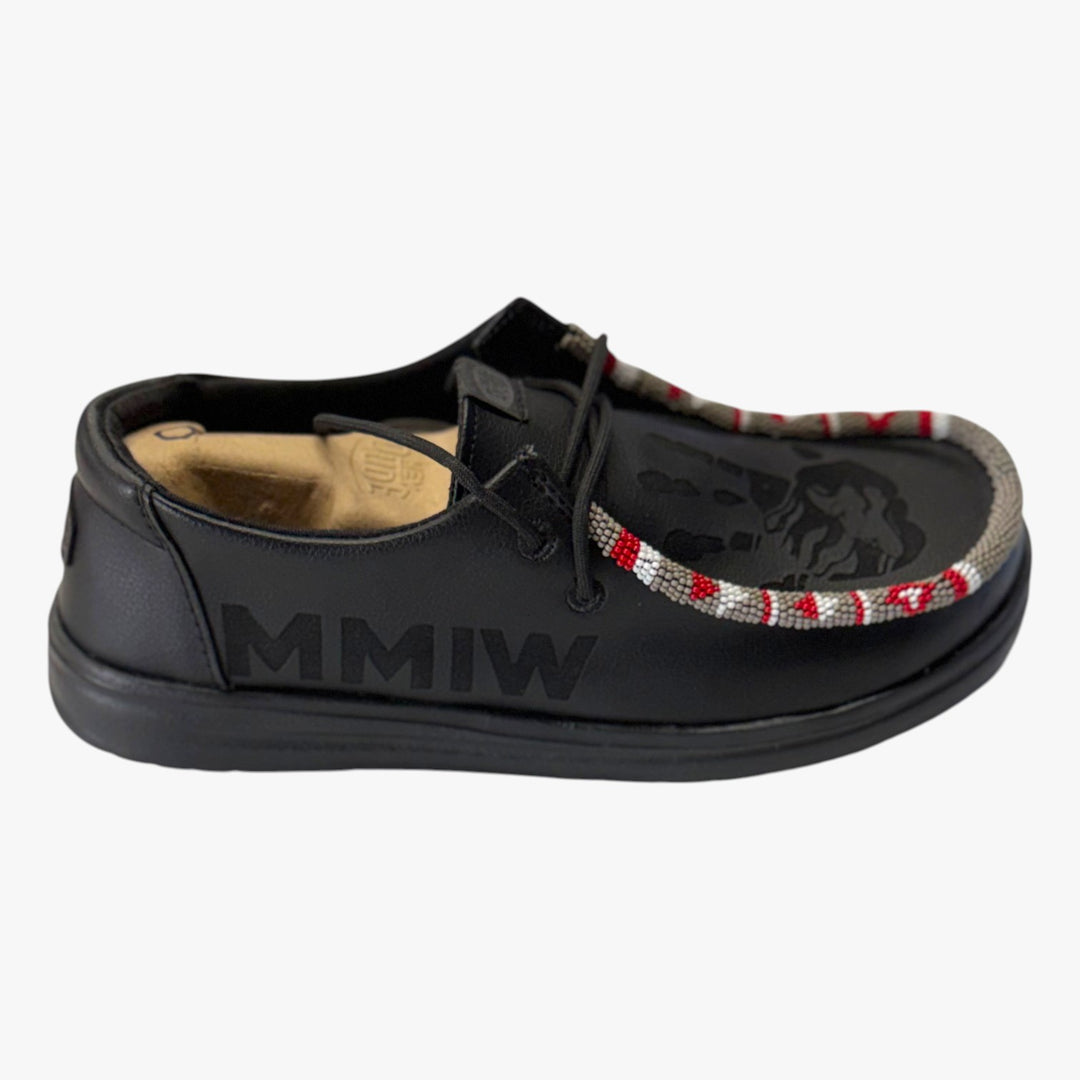 All Nations Designs &amp; More black Hey Dude slip-on shoes featuring laser-etched MMIW text and hand-beaded trim detail.