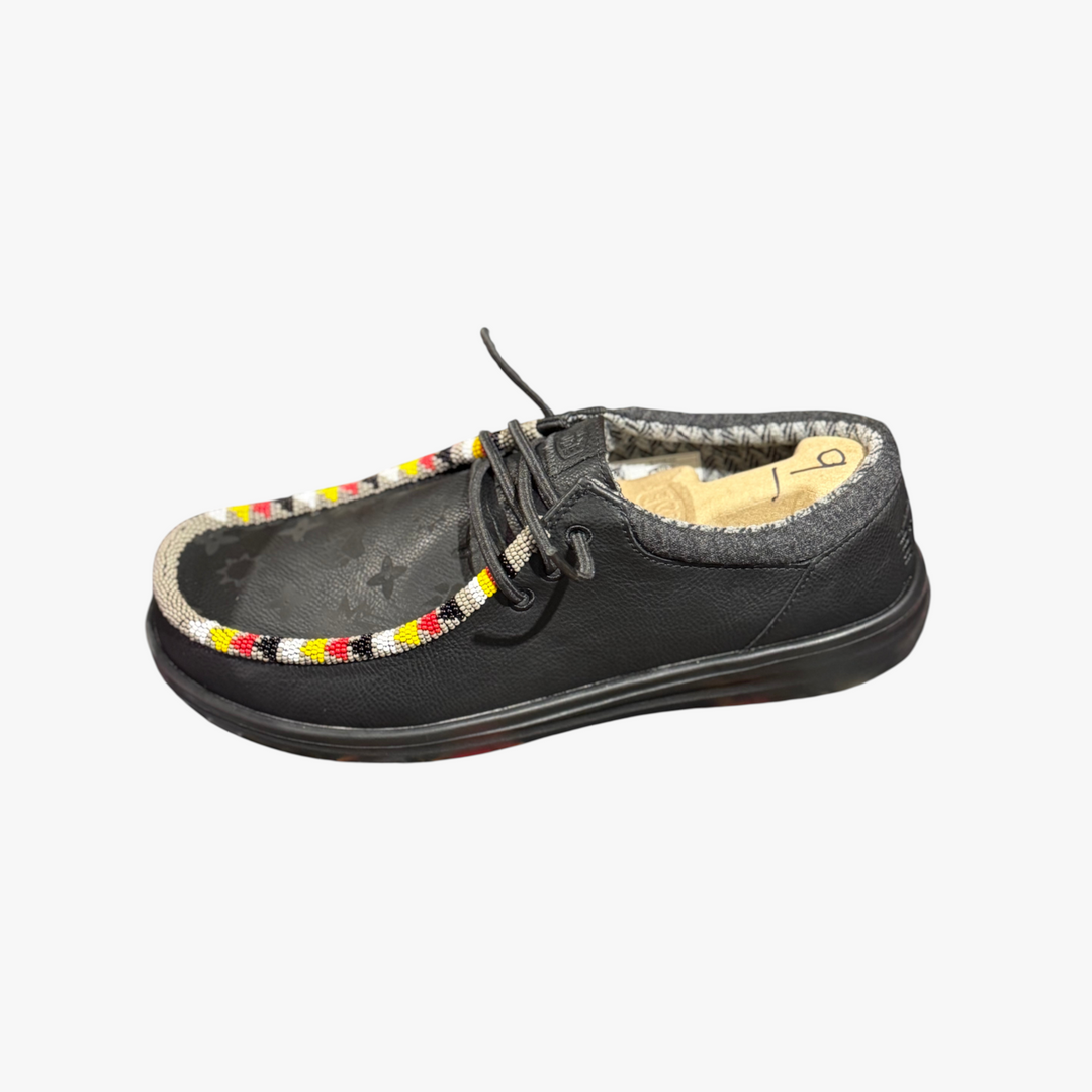 All Nations Designs &amp; More black Hey Dude slip-on shoes featuring custom hand-beaded trim and laser-etched details.