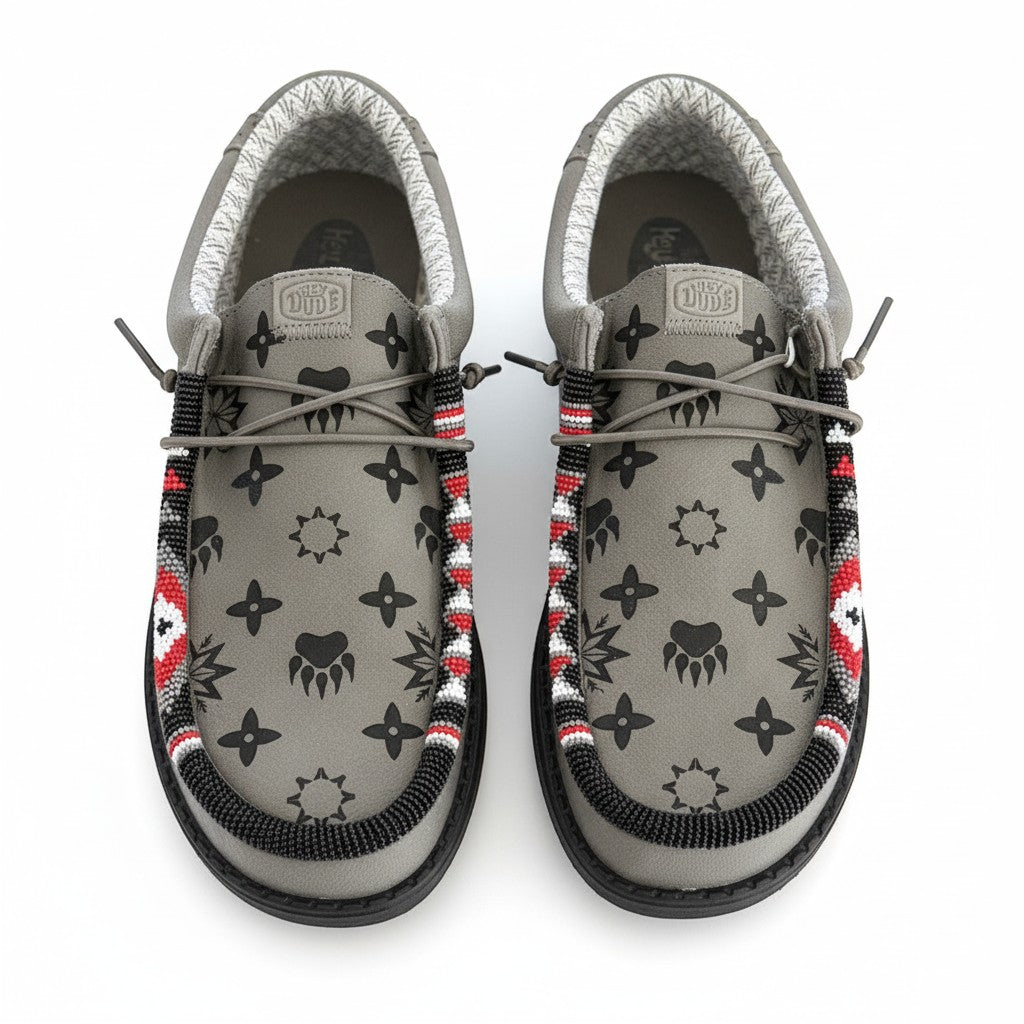 All Nations Designs &amp; More gray Hey Dude slip-on shoes featuring custom hand-beaded trim and black laser-etched patterns.