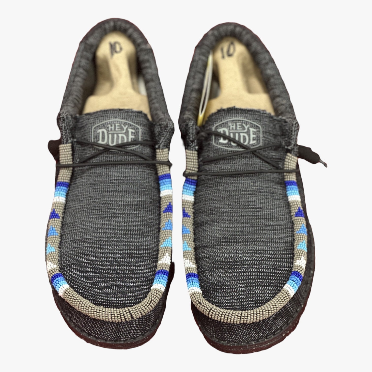 All Nations Designs & More men's gray Hey Dude slip-on shoes featuring custom blue and white hand-beaded trim.