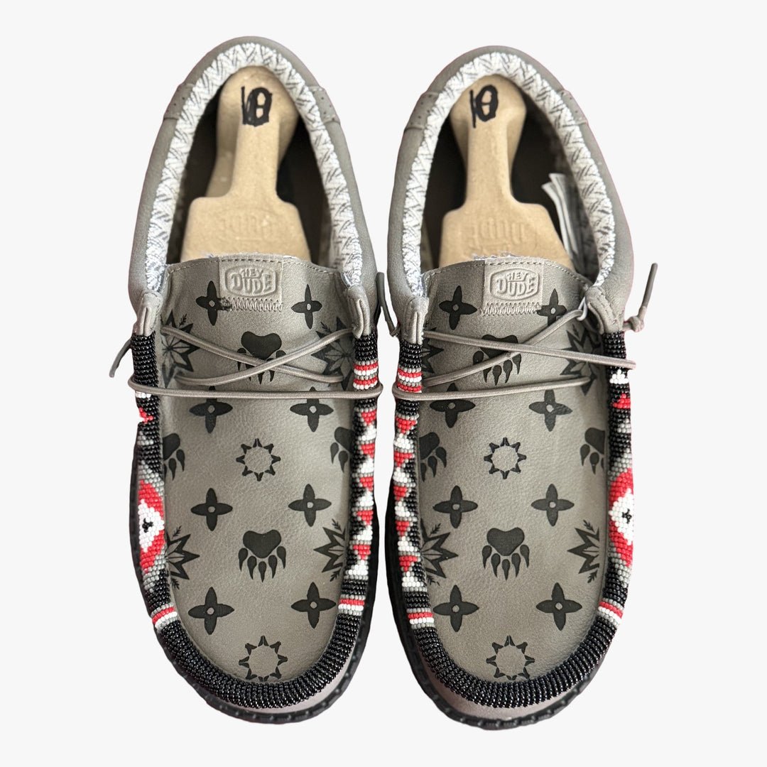 All Nations Designs &amp; More gray Hey Dude slip-on shoes featuring unique hand-beaded trim and laser-etched patterns.