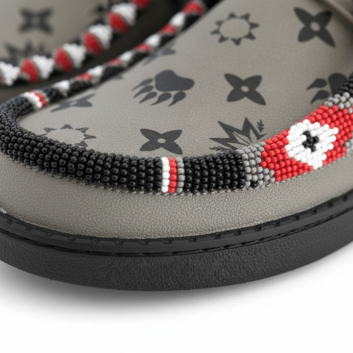 All Nations Designs &amp; More gray Hey Dude slip-on shoes featuring custom hand-beaded trim with red, white, and black patterns.