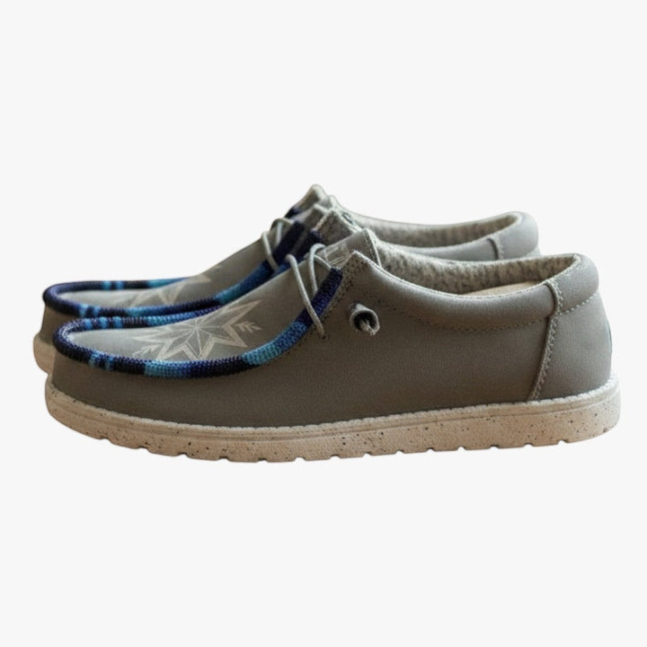 All Nations Designs &amp; More light gray Hey Dude slip-on shoes featuring unique blue and white hand-beaded detailing.