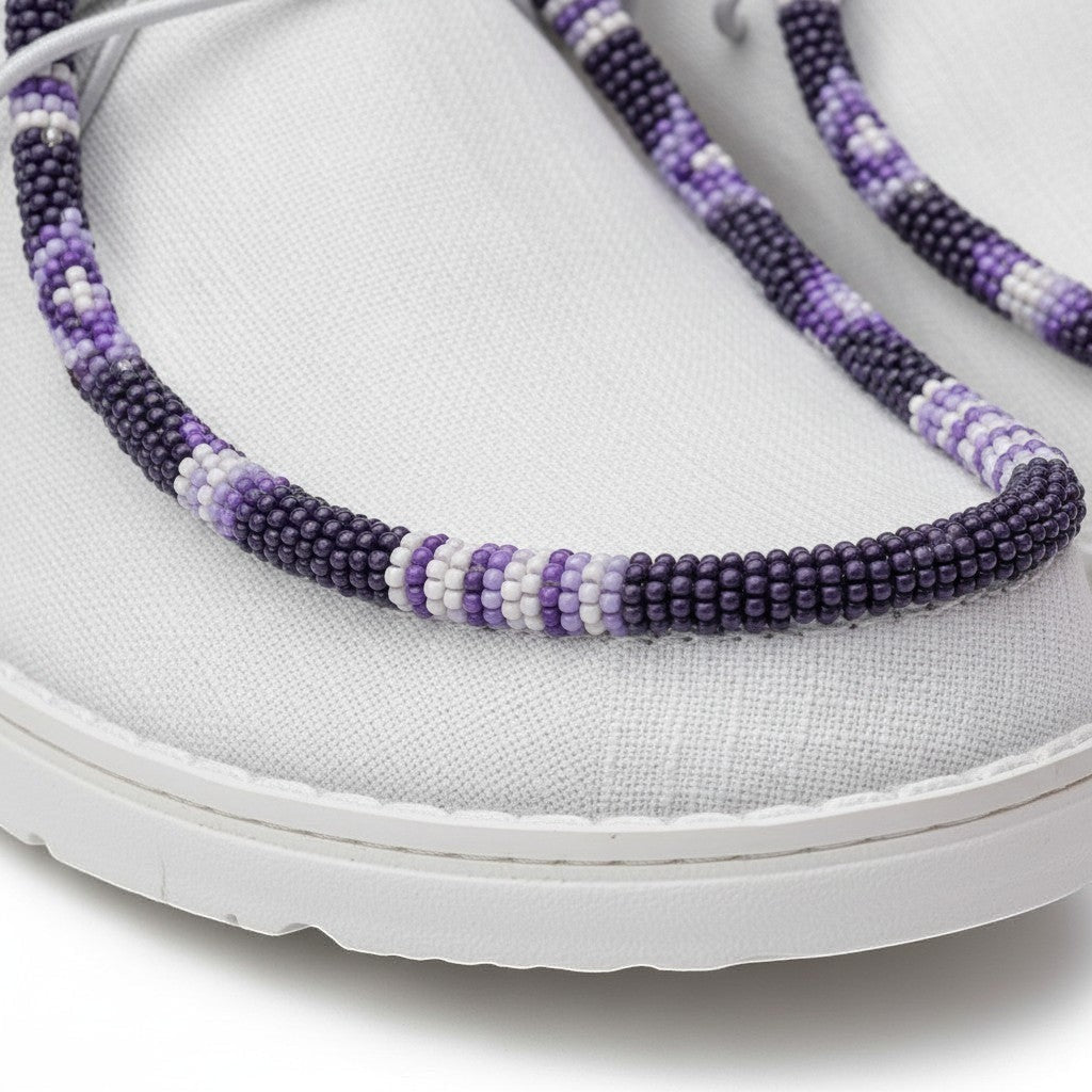 All Nations Designs &amp; More white Hey Dude slip-on shoes featuring intricate purple and white hand-beaded trim detail.