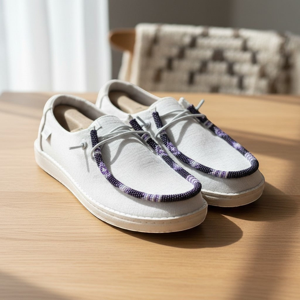 All Nations Designs &amp; More white Hey Dude slip-on shoes featuring custom purple and white hand-beaded trim.