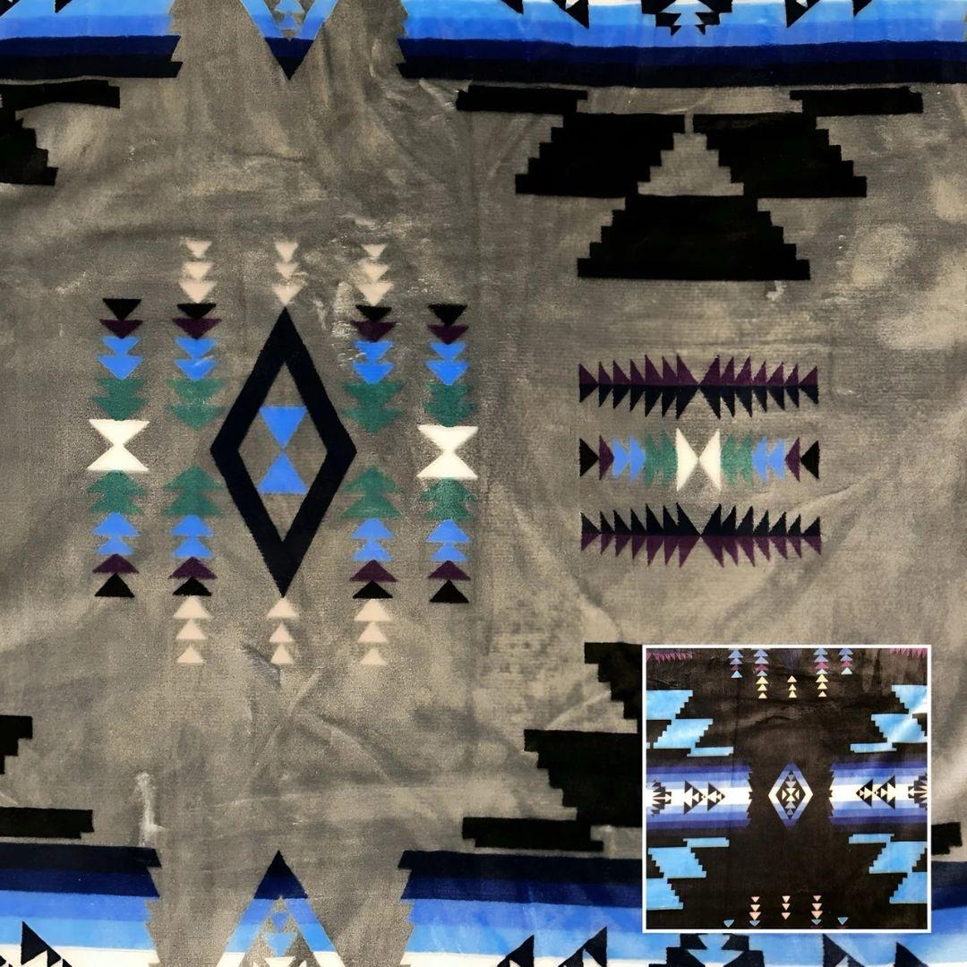 Gray Southwestern-style plush blanket with bold Native-inspired geometric diamond and stripe patterns.