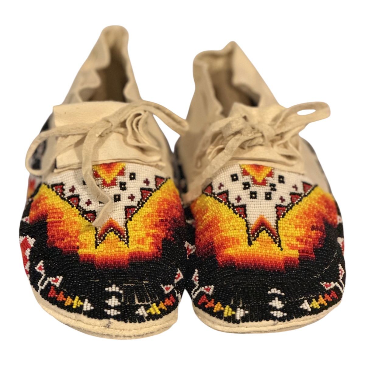 One-of-one fully hand-beaded moccasins, size 9.5, whole pair front view with black, white, yellow, orange and red beadwork