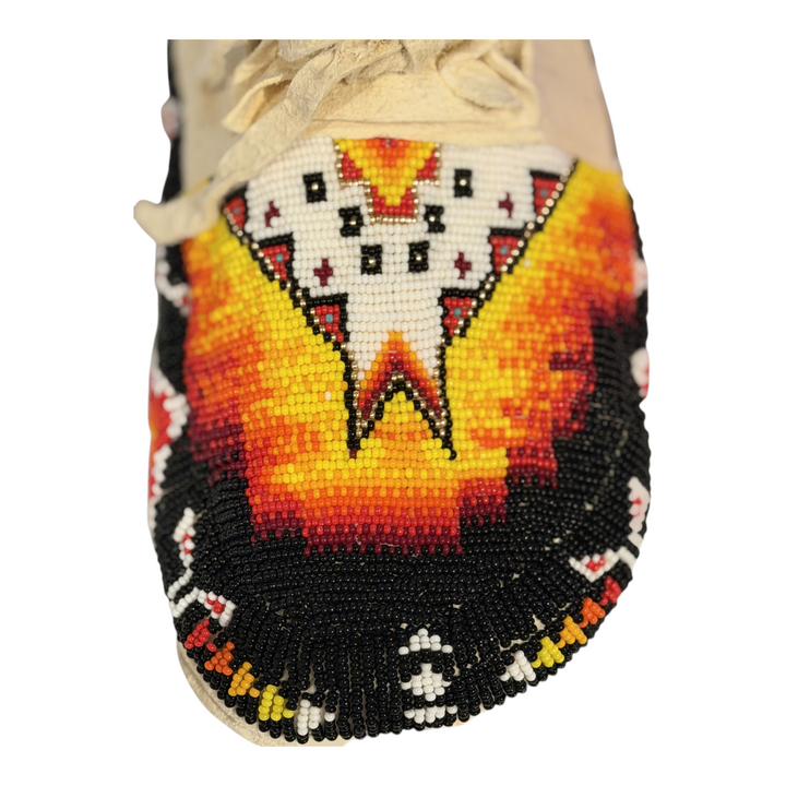 Close-up of the white geometric and yellow, orange, red and black toe beadwork on the size 9.5 moccasins