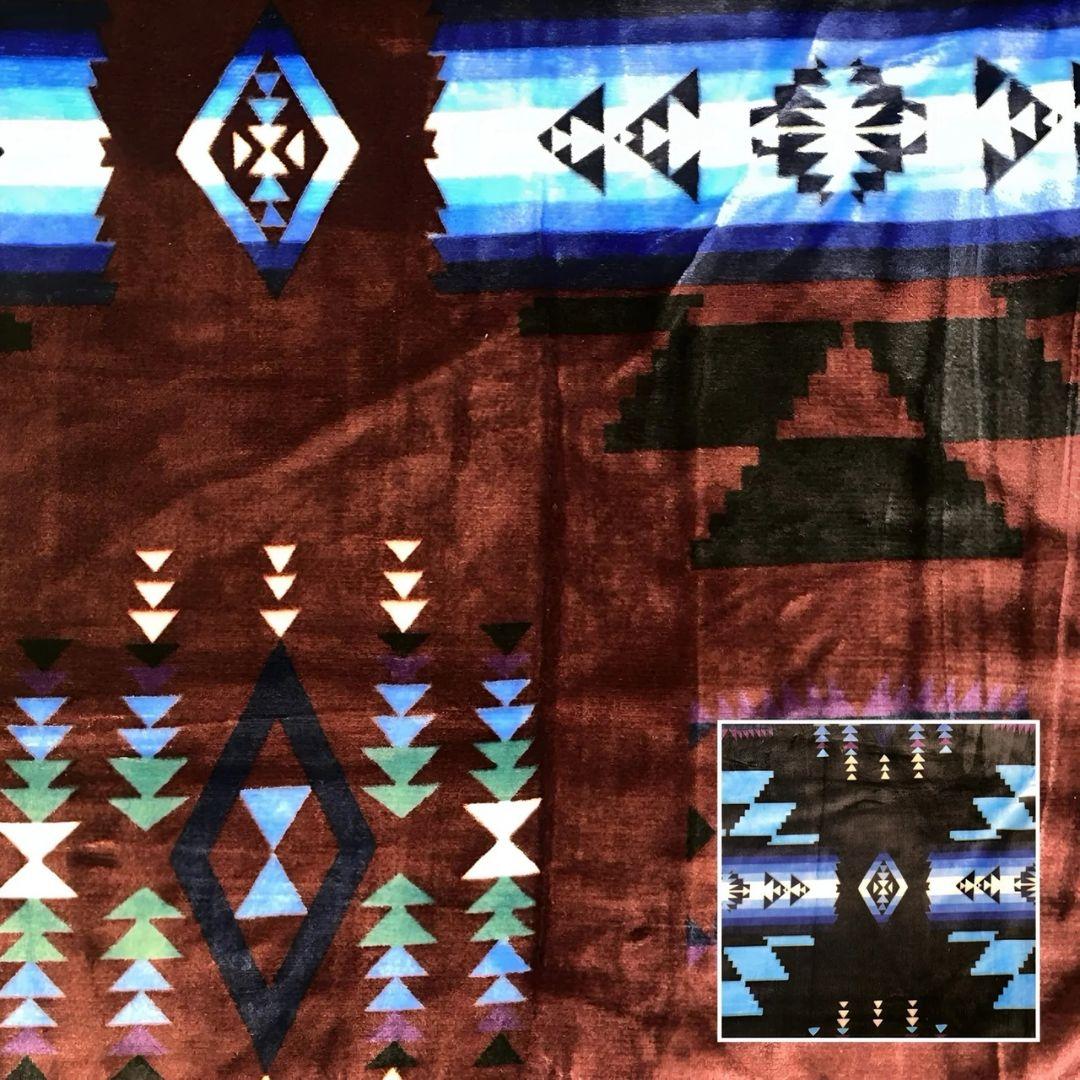 Maroon Southwestern-style plush blanket with bold Native-inspired geometric diamond and stripe patterns.