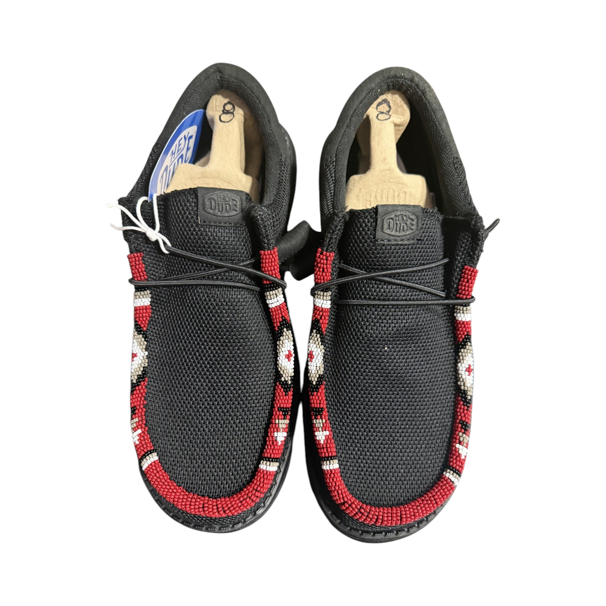 Front view of the exact one-of-one men’s size 8 black Hey Dude Wally shoes with red, white, tan and black hand-beaded trim.