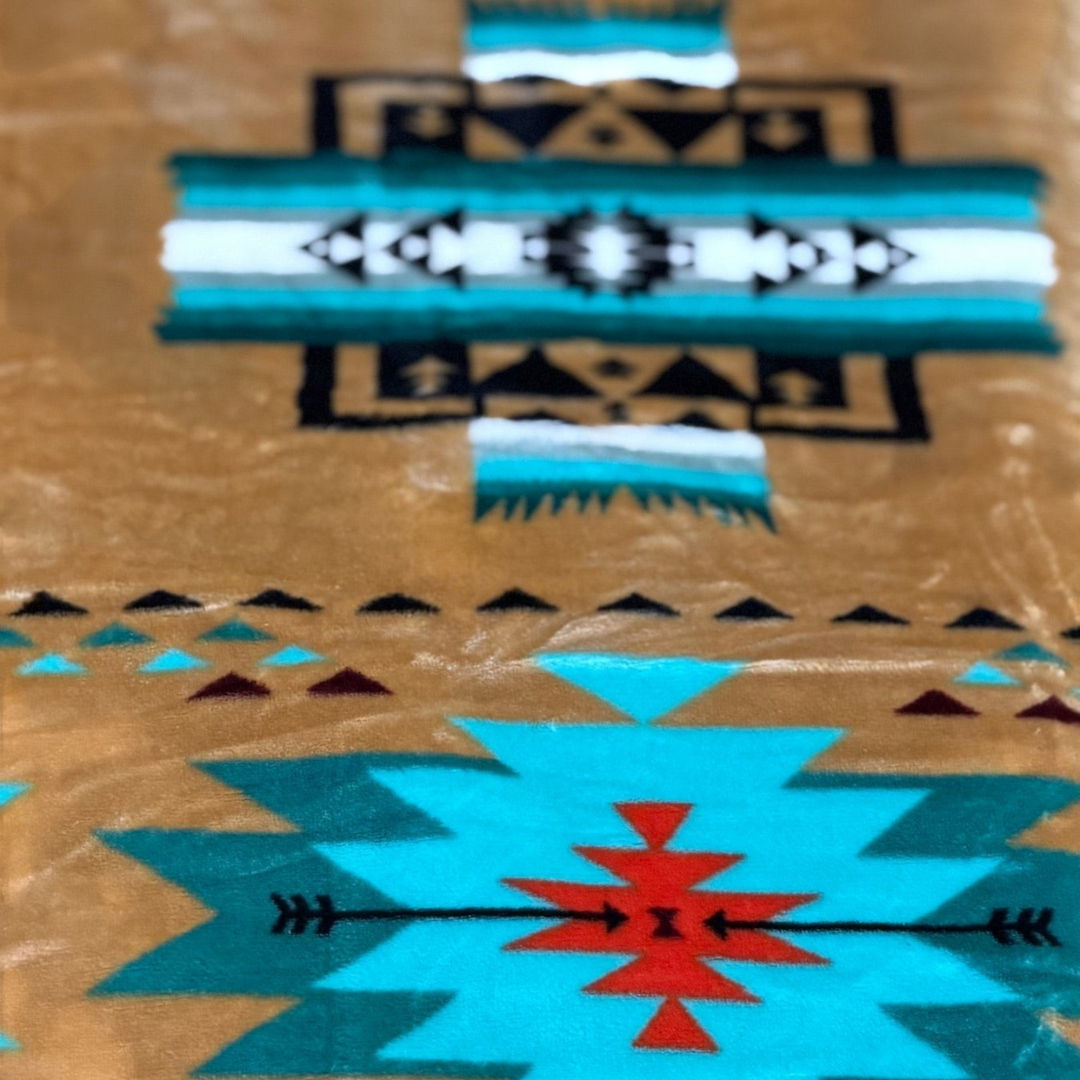 Close-up of the Buckskin SW Sierra blanket showing tan fabric with turquoise, black, white, and orange geometric pattern details.