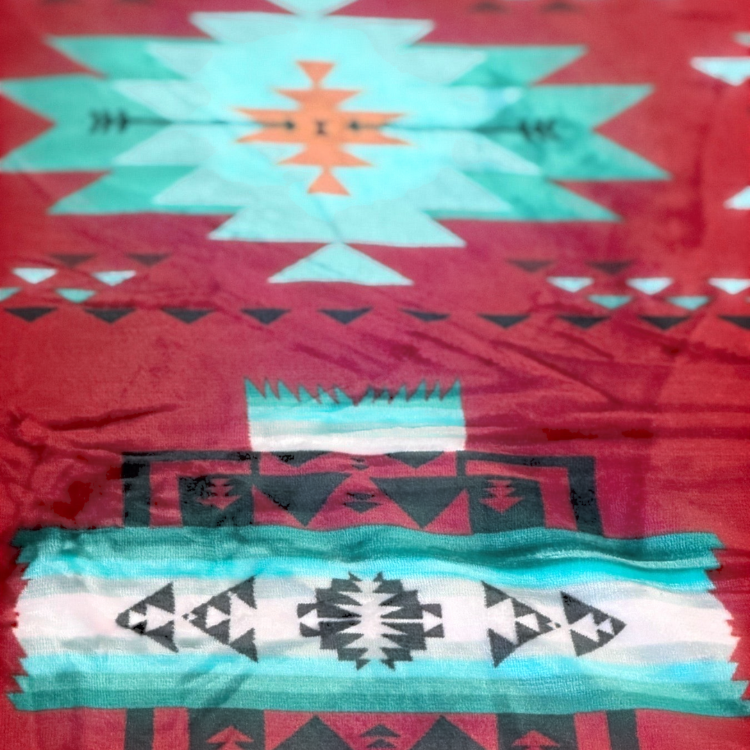 Close-up of the Red SW Sierra blanket showing red fabric with turquoise, white, and black geometric pattern details.