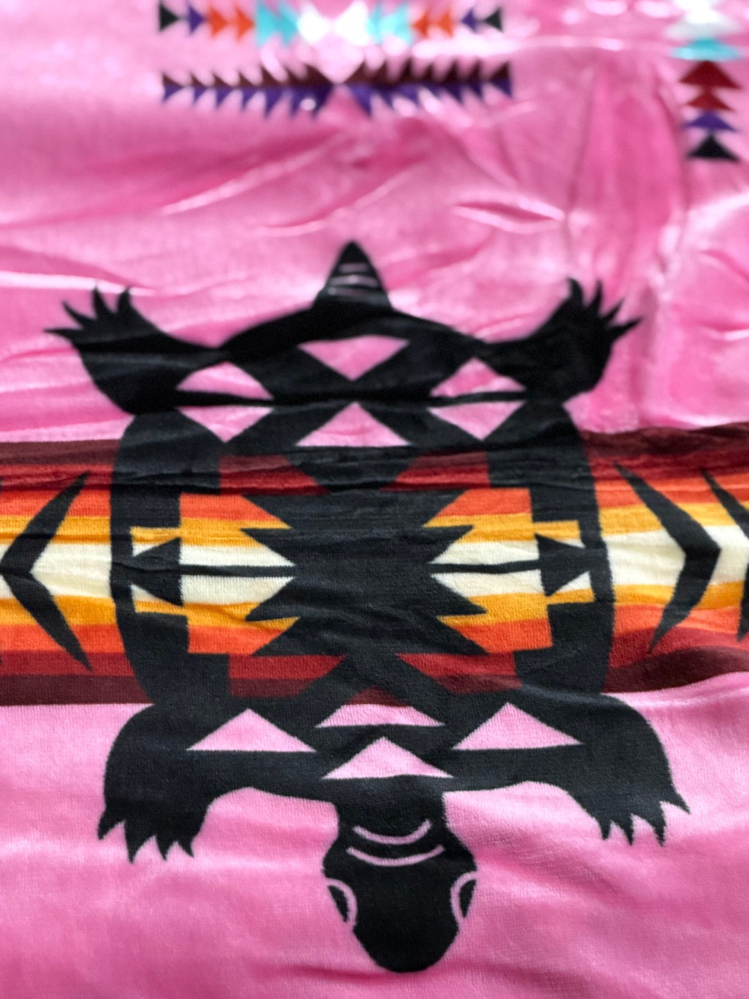 Hot Pink Turtle double-ply blanket close-up showing the turtle motif, geometric borders, and soft fabric texture.